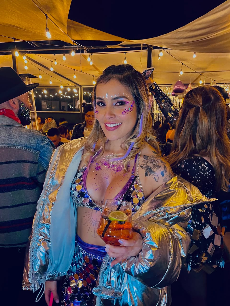Glitter y gemas faciales en una invitada durante un evento nocturno